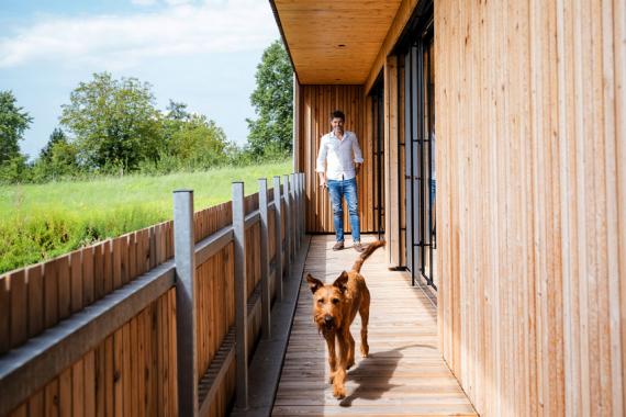 Perfekter Neubau: Hund und Herrchen auf dem Balkon