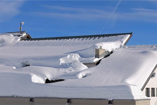 Ins Rutschen geratener Schnee auf Hausdach