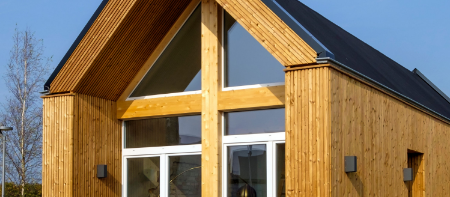 Kleines Holzhaus mit großer Fensterfront am Spitzgiebel