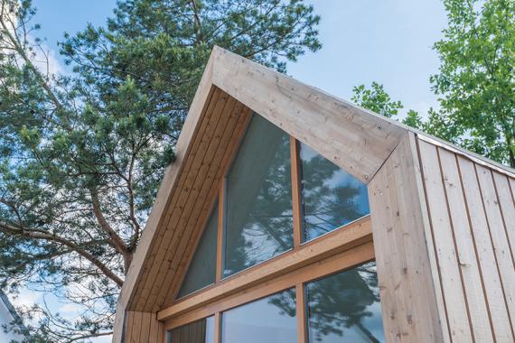 Front-/Giebelansicht eines Holzhauses mit großer Fenster über die ganze Fläche