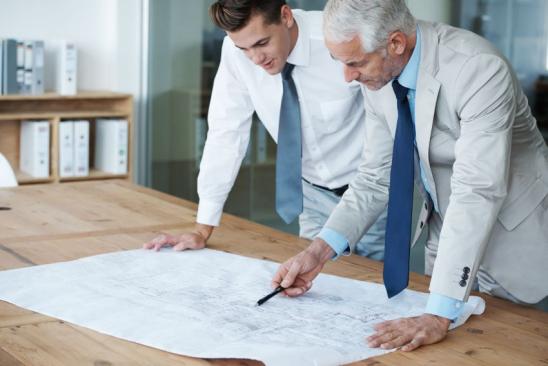 Two corporate Architects going over the plans of a building together