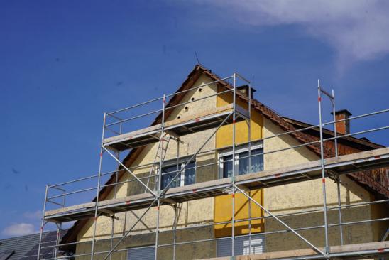 Erneuerung der Fassade an einem eingerüsteten Einfamilienhaus