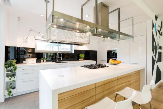 Offene Küche mit großzügiger Arbeitsfläche und moderner Abzugskonstruktion aus Stahl