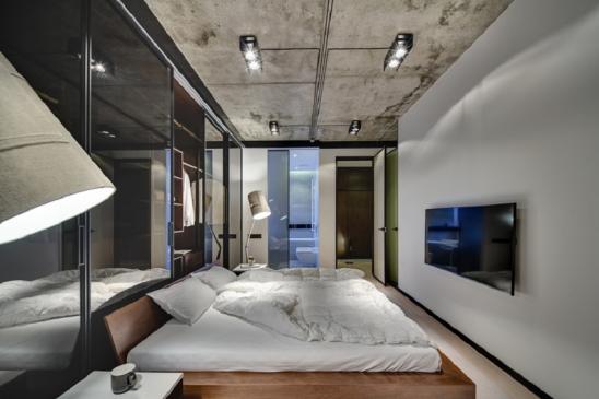 Schlafzimmer im Loftstil mit weißen Wänden und Betondecke
