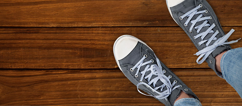 Füße in Schuhen auf Holzboden