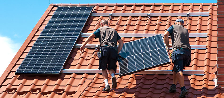 Facharbeiter installieren Solarkollektoren aufs Hausdach